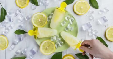 Bazı insanların buzlu tabaktan birer birer aldığı ferahlatıcı limonlu dondurmaların en üst görüntüsü. 4K 'de eğlence durağı hareketi. Bahar ve yaz zamanı.