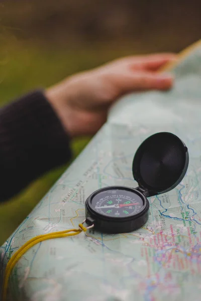 Hand holding compass and map on summer background