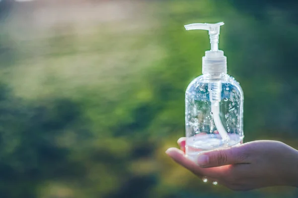Átlátszó fehér műanyag botle antibakteriális fertőtlenítő folyadék a kezében, tiszta háttér — Stock Fotó