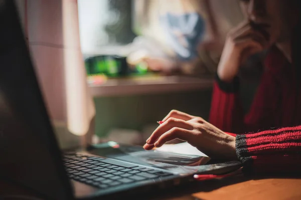 Ung kaukasiska flicka i röd tröja med förvirrad blick på hennes ansikte tittar på datorn när du studerar online hemma — Stockfoto