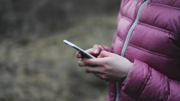Hands in pink jaket holding while mobile phone — Stock Video