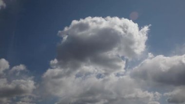 Gün içinde hızlandırılmış video boyunca mavi gökyüzü ile hızlı hareket eden parlak beyaz bulutlar
