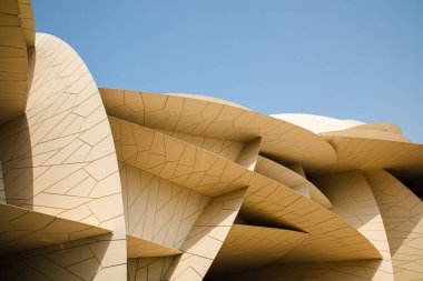 Modern çağdaş mimari Katar Ulusal Müzesi. Yazan: Jean Nouvel Doha şehrinde mavi gökyüzü arka planıyla