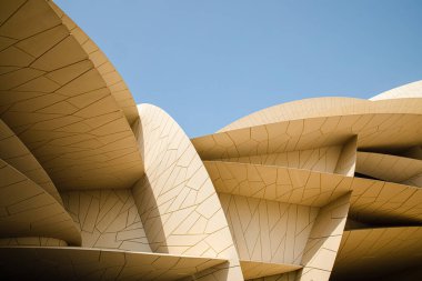 Modern çağdaş mimari Katar Ulusal Müzesi. Yazan: Jean Nouvel Doha şehrinde mavi gökyüzü arka planıyla