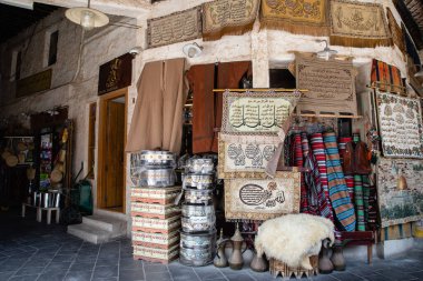 Doha, Katar - 2 Mart 2020: Katar 'ın Doha şehrinde halı ve giysi satan geleneksel Arap pazarı Souq Waqif' e bakın