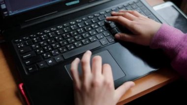 Pencerenin yanındaki evde çevrimiçi programlama öğrenirken bilgisayardaki kız