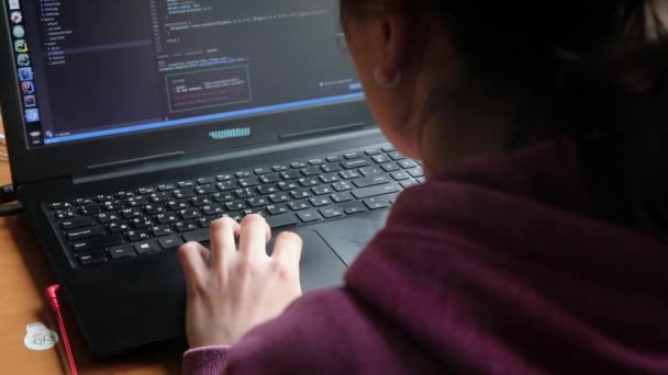 Дівчина за комп'ютером вивчає онлайн-програмування вдома біля вікна — стокове відео
