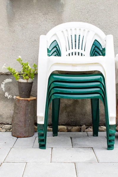 Bahçedeki Eski Desenli Duvarın Yanında Plastik Sandalyeler Yığını — Stok fotoğraf