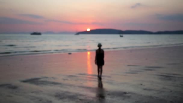 Een meisje lopend op een strand tot zonsondergang — Stockvideo