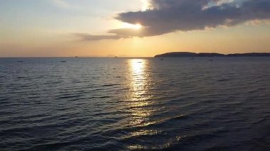 Andaman Denizi üzerindeki Ao Nang sahil kasabasında güzel bir sahil gün batımı, Krabi, Tayland. Yüksek kaliteli görüntüler, insansız hava aracı videosu