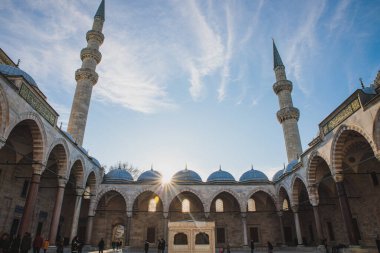 İstanbul, Türkiye - Aralık 2018: Bahçenin içinde güzel güneş ışığı ve mavi gökyüzünde minareler bulunan Süleyman Camii 'ne bakın