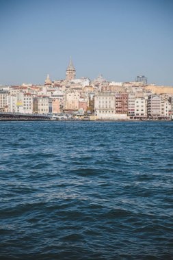 Limandaki su dalgaları ve temiz gökyüzü arkaplanı, Galata kulesi, Karaköy ilçesi ve Türkiye 'deki Altın Boynuz manzaralı eski İstanbul kenti silüeti