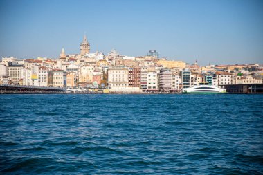 Limandaki su dalgaları ve temiz gökyüzü arkaplanı, Galata kulesi, Karaköy ilçesi ve Türkiye 'deki Altın Boynuz manzaralı eski İstanbul kenti silüeti