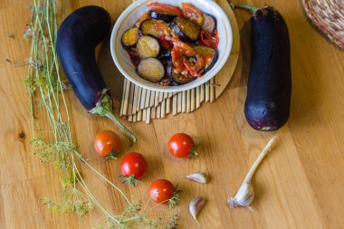 Domatesli ve patlıcanlı ev yapımı sebze güveci leçosu ahşap masa üzerinde yassı flatlay