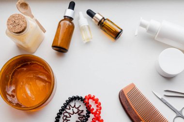 Güzellik ürünleri düz çizilmiş beyaz arka plan, saç bakımı ve yüz bakımı öğeleri, salyangoz losyonu, serum, ahşap tarak ve boş ambalajlı spa detayları uzanıyordu