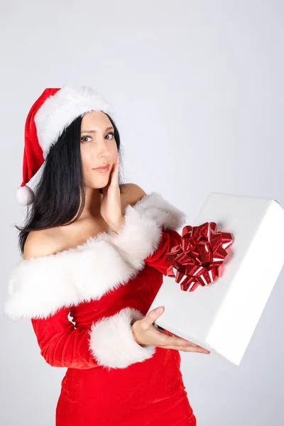 Père Noël avec un cadeau. Une fille en costume de Père Noël tient une boîte cadeau sur un fond blanc . — Photo