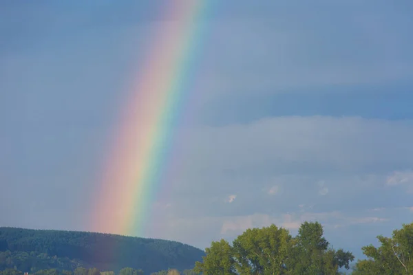 Ein Stück Regenbogen am Himmel vor dem Hintergrund der Regenwolken. — Stockfoto