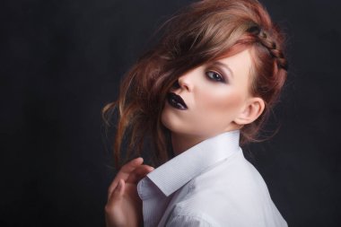 Profesyonel makyajlı erkek gömleği giymiş güzel bir kız. Kızıl saç tonları, siyah ruj ve gevşek saçlar..