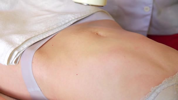 Masaje corporal con cavitación. Chica joven en la mesa de masaje anti celulitis masaje — Vídeo de stock