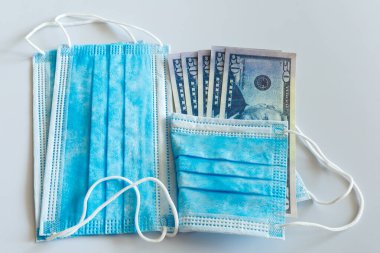 Tıbbi maskeler ve 50 dolarlık banknotlar, solunum yolunun virüslerden korunması için daha yüksek fiyatların sembolü..