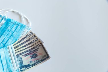 Tıbbi maskeler ve 50 dolarlık banknotlar, solunum yolunu virüslerden korumak için artan fiyatların sembolü. Kopyalama için bir yer var.