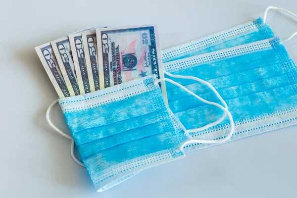 Tıbbi maskeler ve 50 dolarlık banknotlar, solunum yolunun virüslerden korunması için daha yüksek fiyatların sembolü..