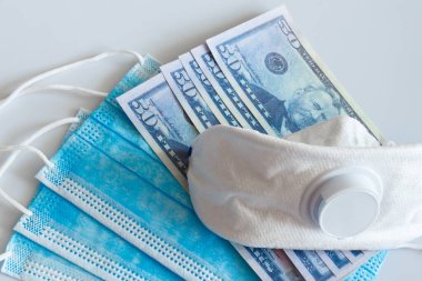 Tıbbi maskeler ve 50 dolarlık banknotlar, solunum yolunu virüslerden korumak için artan fiyatların sembolü. Kopyalama için bir yer var.