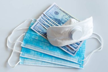 Tıbbi maskeler ve 50 dolarlık banknotlar, solunum yolunu virüslerden korumak için artan fiyatların sembolü. Kopyalama için bir yer var.