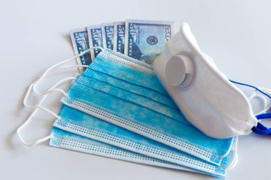 Tıbbi maskeler ve 50 dolarlık banknotlar, solunum yolunu virüslerden korumak için artan fiyatların sembolü. Kopyalama için bir yer var.