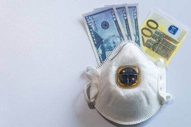 Tıbbi maske altında Amerikan ve Avrupa para birimlerinin banknotları.