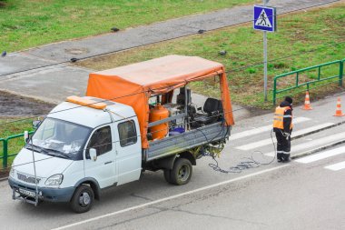 Özel bir makine kullanarak asfalta yol işaretleri uygulamak. Yazı