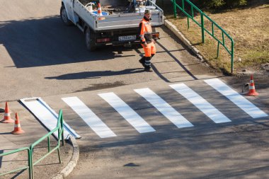 Özel bir makine kullanarak asfalta yol işaretleri uygulamak. Yazı