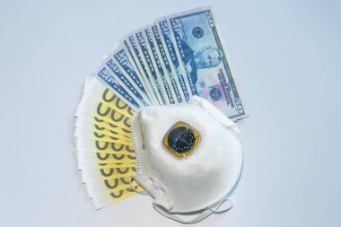 Dolar banknotları ve avroların arka planına karşı bir solunum cihazı. Pahalı ilaç konsepti.