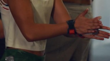 Spor salonundaki genç kadın beyaz tebeşirle el çırpıyor.