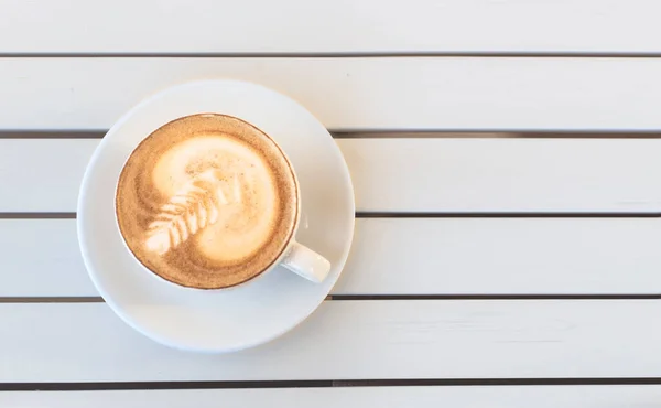 Bovenaanzicht van kleine coppucino cup op witte houten panelen. — Stockfoto