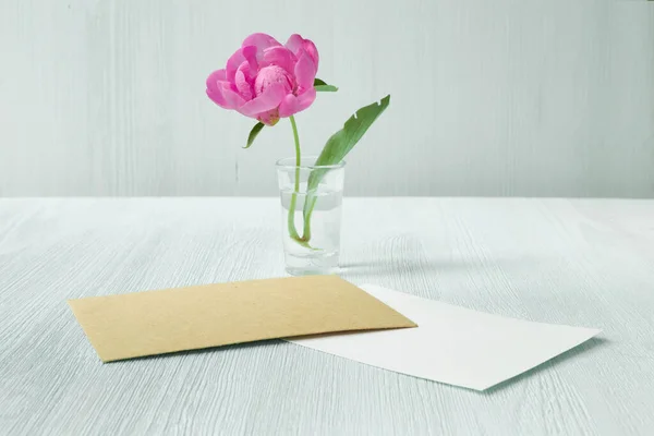 Grußkarte, beiger Umschlag mit Pfingstrosenblumen. — Stockfoto