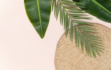 Yuvarlak hasır sehpa ve pembe arka planda palmiye yaprakları. Metin yeri ile fltlay biçimi kavramı