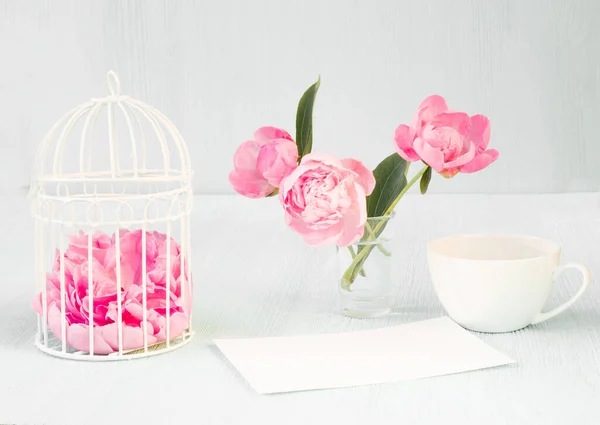 Pequena gaiola de pássaro com buquê de flor de peônia, copo de café de aroma pequeno , — Fotografia de Stock