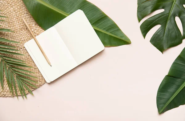 Conceito de estilo Fltlay com lugar de texto no centro e na borda do notebook, lápis com suporte de vime redondo e folhas de palma tropicais no fundo rosa — Fotografia de Stock