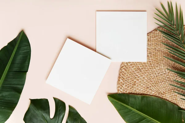 Conceito de estilo Fltlay com lugar de texto no centro, folha de papel branco, lápis com suporte de vime redondo e folhas de palma tropicais no fundo rosa — Fotografia de Stock
