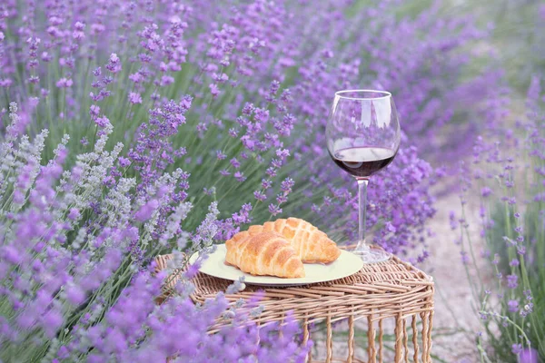 Wine and croissant against lavender landscape. — Stock Photo, Image