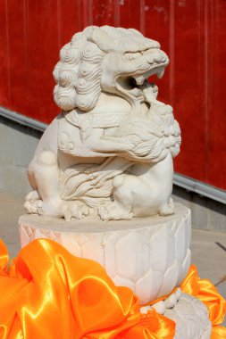 Taş Aslanlar, bir kırmızı saten ile bağlı yakın çekim