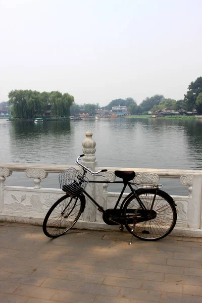 Den gamla oanvända cykeln låg på räcket houhai lake Park, Beijing — Stockfoto