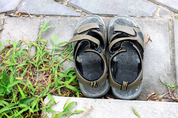 Oude zwarte slippers sandaal op de begane grond — Stockfoto