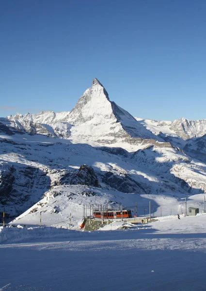 Vista panorámica del pico nevado de Matterhorn en un día soleado con cielo azul y algunas nubes en el fondo — Foto de Stock