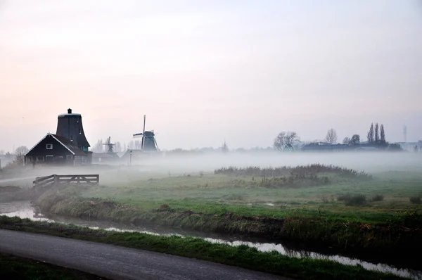 The early morning in the town of Kinderdijk in Netherlands, with a heavy fog and village view — стоковое фото