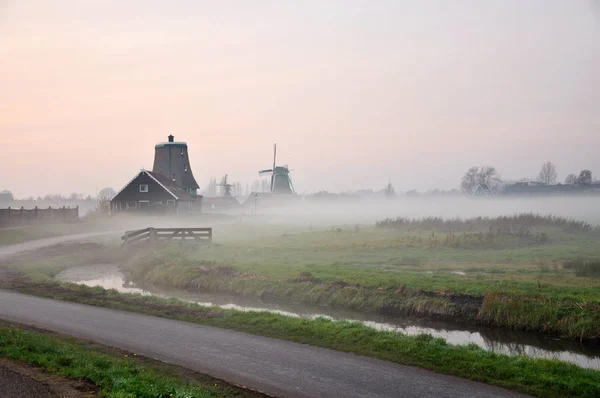 Tidigt på morgonen i den staden Kinderdijk i Holland, med en tung dimma och byn Visa — Stockfoto