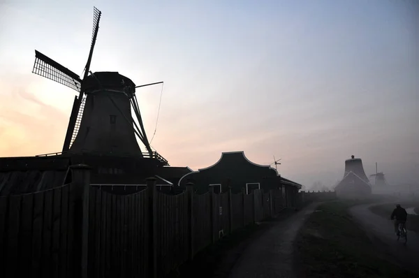 A windemill a városban Kinderdijk Hollandiában, a táj, a falu, a folyó, a rét és a mezőgazdasági — Stock Fotó