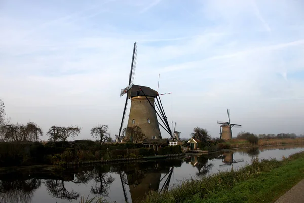 A windemill a városban Kinderdijk Hollandiában, a táj, a falu, a folyó, a rét és a mezőgazdasági — Stock Fotó