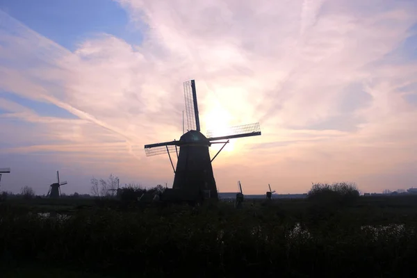 De windemill in de stad van de Kinderdijk in Holland, met het landschap van dorp, rivier, weide en boerderij — Stockfoto